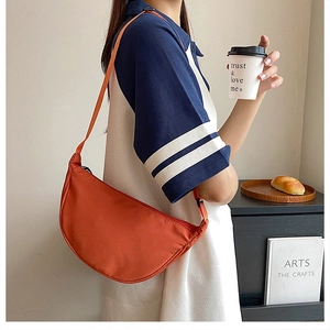 Retro orange nylon crescent bag styled in a casual lifestyle setting with a shoulder strap