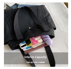 Interior view of black canvas tote bag showing large capacity for books, tablet and umbrella