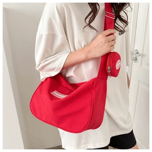 Dettaglio della borsa in nylon rosso con tracolla regolabile e mini portamonete rimosso