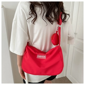 Détail du sac à bandoulière rouge imperméable avec son pendentif porte-monnaie assorti