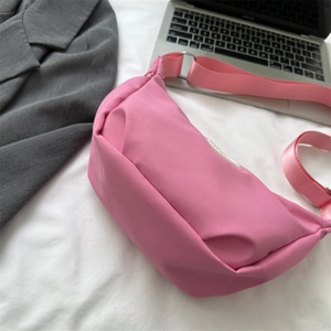 Minimalist pink nylon crescent crossbody bag with adjustable wide strap and metal buckle