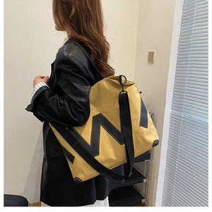 Détail du cabas en toile jaune avec logo W noir et longue bandoulière réglable