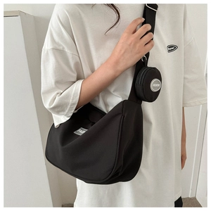 Détail du sac demi-lune en nylon noir avec bandoulière large et petit porte-monnaie rond