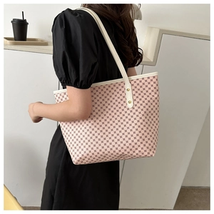 Detail of pink geometric pattern tote bag with white leather straps and gold rivets