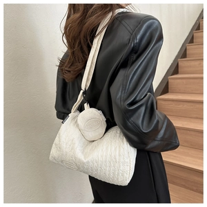 Close-up of a white quilted nylon dumpling bag with a small round coin purse attachment
