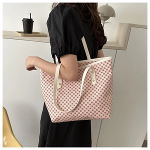 Close-up of pink tote bag with geometric pattern and white handle showing rivet details