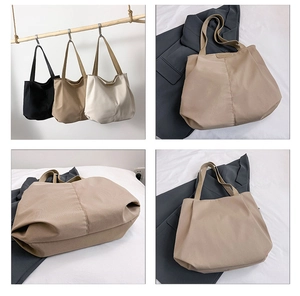 Detail view of large canvas tote bag in black, khaki and beige with long shoulder straps