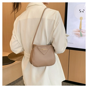 Litchi texture leather shoulder bag shown from back view on model for lifestyle context