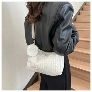 Quilted white shoulder bag with a round coin pouch worn over a black leather jacket