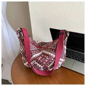 Detailed shot of ethnic knit crossbody bag with red and brown geometric patterns