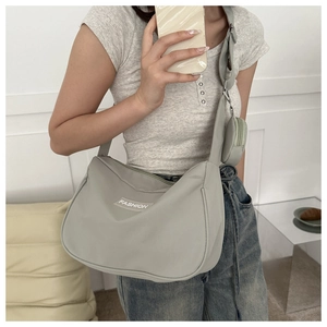 Dettaglio della borsa a tracolla in nylon grigio con portamonete rotondo abbinato