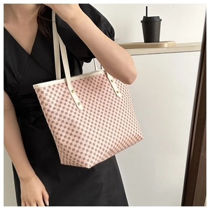 Detail of pink geometric pattern tote bag with white leather straps and gold rivets