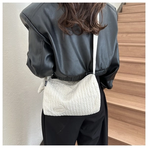 White quilted bubble texture nylon shoulder bag shown on model in black leather jacket