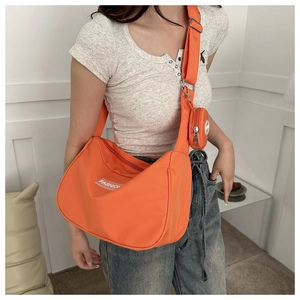 Vue détaillée d'un sac bandoulière orange en nylon avec un mini porte-monnaie rond