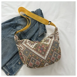 Detail of bohemian woven crossbody bag with colorful patterns and yellow nylon strap