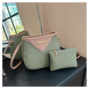 Detail view of olive green bucket bag set with matching coin purse and gold spindle hardware