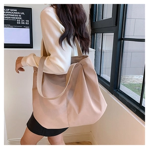 Detailed side view of large canvas tote bag in nude pink on a fashion model