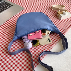 Blue nylon crescent bag showing large capacity for umbrella, wallet and smartphone