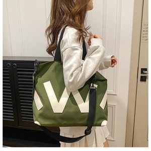 Détail du grand sac cabas en toile avec lettre V blanche et bandoulière noire