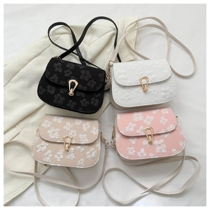 Detail view of four textured floral embroidery handbags in black, white, beige, and pink