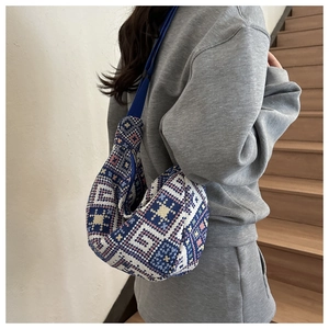 Close-up of ethnic geometric pattern jacquard hobo bag with a blue strap on a model