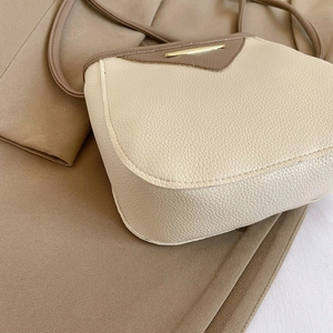 Minimalist beige pebble leather crossbody bucket bag with brown trim and gold hardware