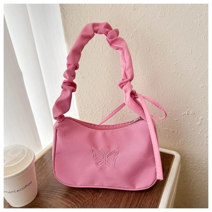 Détail d'un petit sac carré rose avec broderie papillon et poignée plissée élégante