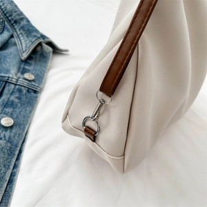 Minimalist canvas tote bag with brown leather trim and metal swivel clasp detail