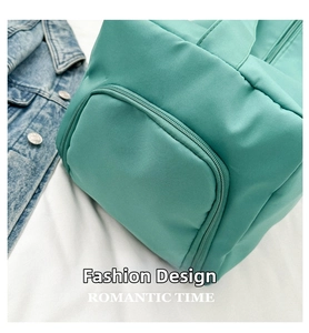 Detail of mint green nylon gym bag featuring large side pocket and zipper closure