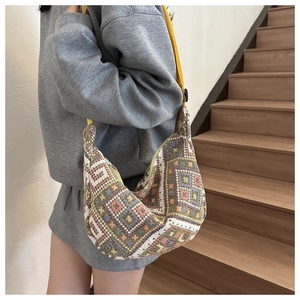 Close-up of bohemian geometric knit pattern on a hobo bag with yellow strap detail