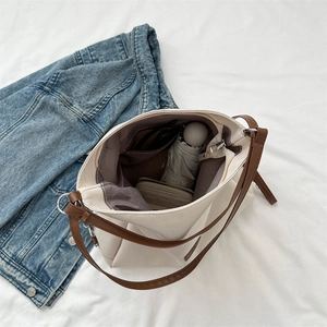 Large capacity off-white canvas tote bag with brown straps showing spacious interior