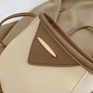 Chic two-tone bucket bag in off-white and brown pebbled leather with gold leaf hardware