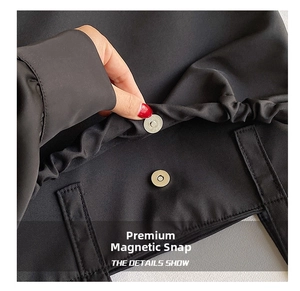 Detail view of high-quality magnetic snap fastener on black knit fabric tote bag