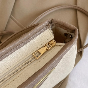 Chic beige and brown contrast bucket bag with textured leather and gold zipper