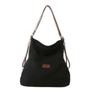 Minimalist black canvas tote bag with brown straps and leather patch for daily use