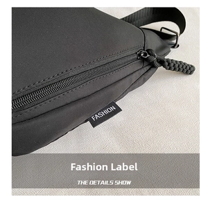 Detailed macro view of black nylon canvas bag featuring a fashion label and rope zipper