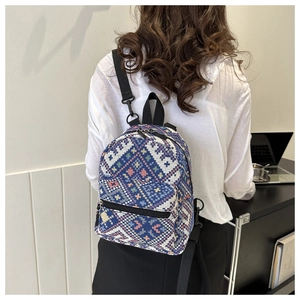 Détail d'un mini sac à dos au motif jacquard géométrique porté par un modèle
