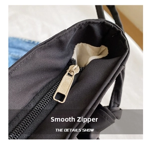 Detail shot of smooth silver zipper closure on large black waterproof tote bag