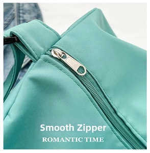 Detailed close-up of a smooth silver metal zipper on a mint green nylon travel bag