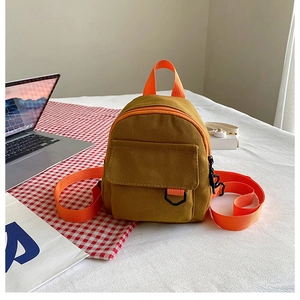 Détail d'un mini sac à dos en toile jaune et orange avec poche à rabat frontale