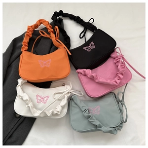 Détail de divers sacs sous les bras avec broderie papillon et bandoulières plissées