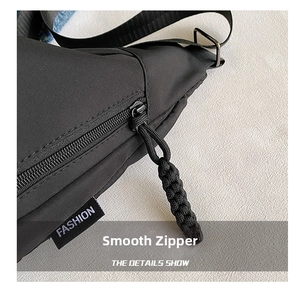 Detail of smooth black nylon zipper with a woven pull cord and a Fashion label tag