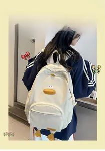 Detail of cute cream corduroy backpack featuring yellow 3D duck beak and leg accents