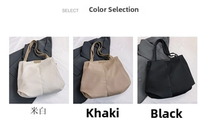 Three minimalist canvas tote bags in white, khaki, and black displayed with a gray blazer