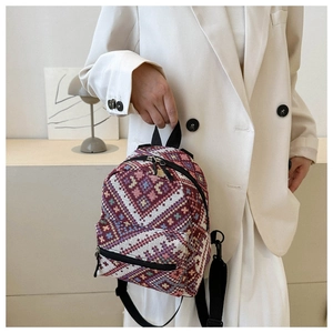 Détail du tissage jacquard ethnique rouge sur un grand sac à dos en toile pour femmes