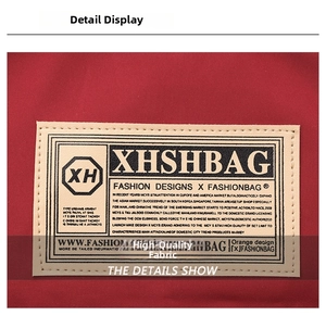 Dettaglio del tessuto rosso ad alta densità con patch logo cucita di qualità sullo zaino