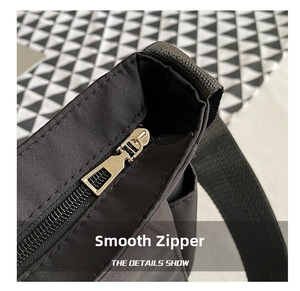 Close-up of smooth black zipper and silver metal slider on minimalist messenger bag