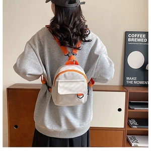 Mini sac à dos en toile avec bretelles orange et poche avant porté par un mannequin