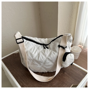 Detalle de bolso bandolera acolchado blanco con monedero redondo y cremallera negra