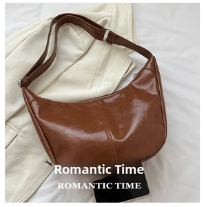 Brown faux leather crescent bag detail with wide adjustable strap and size comparison